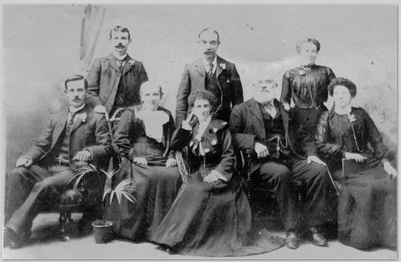 Family portrait photograph of a man, his wife, and their three daughters and three sons.