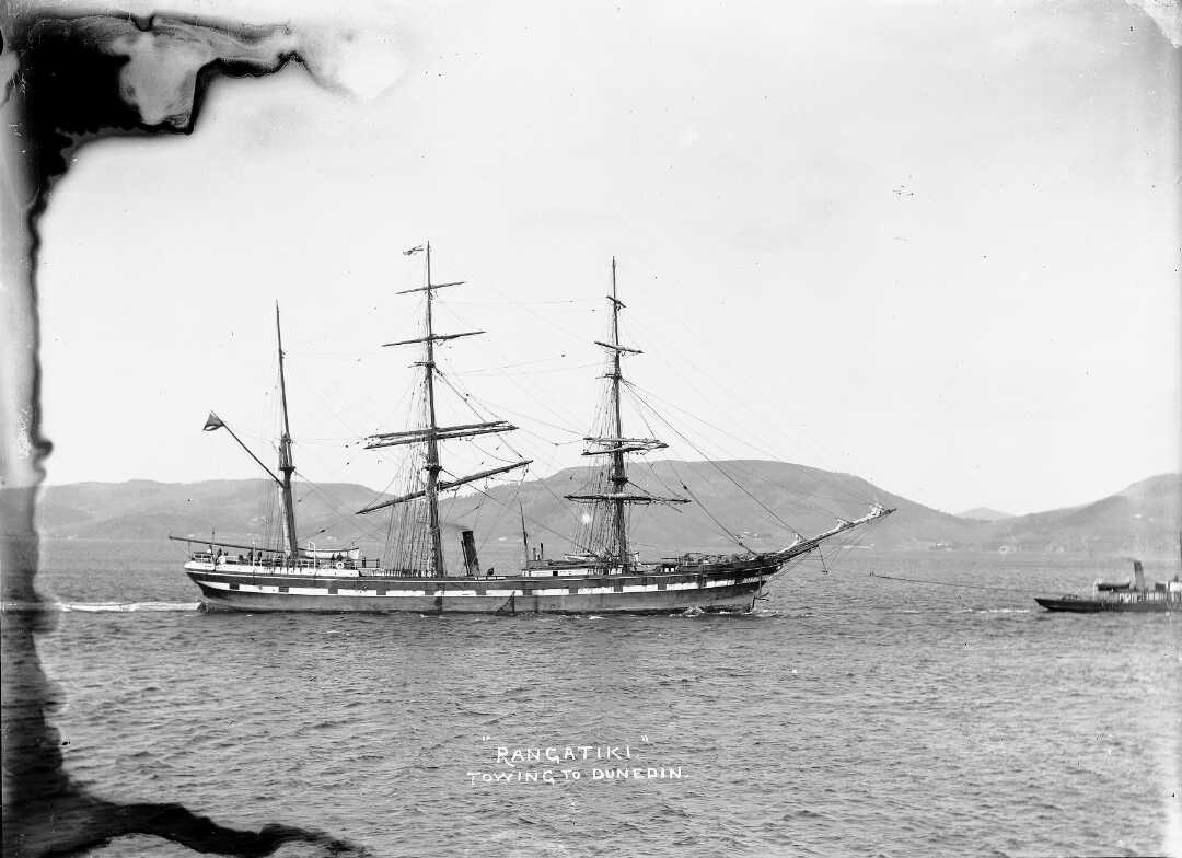 Steamship being towed by a smaller boat to the right.